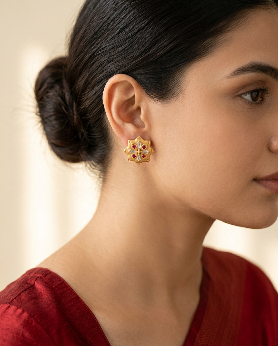 Model wearing the Kesar matte-gold star studs with ruby-red stones